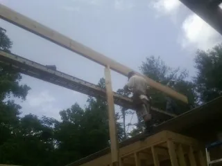 Carpenter setting a ridge beam over a new addition frame — Ice Dam Removal by Roofing Brothers in Mc Dermitt