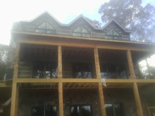 Dormers and porch framing on a large log home under construction — Roof Coating work by our crew in Mc Dermitt