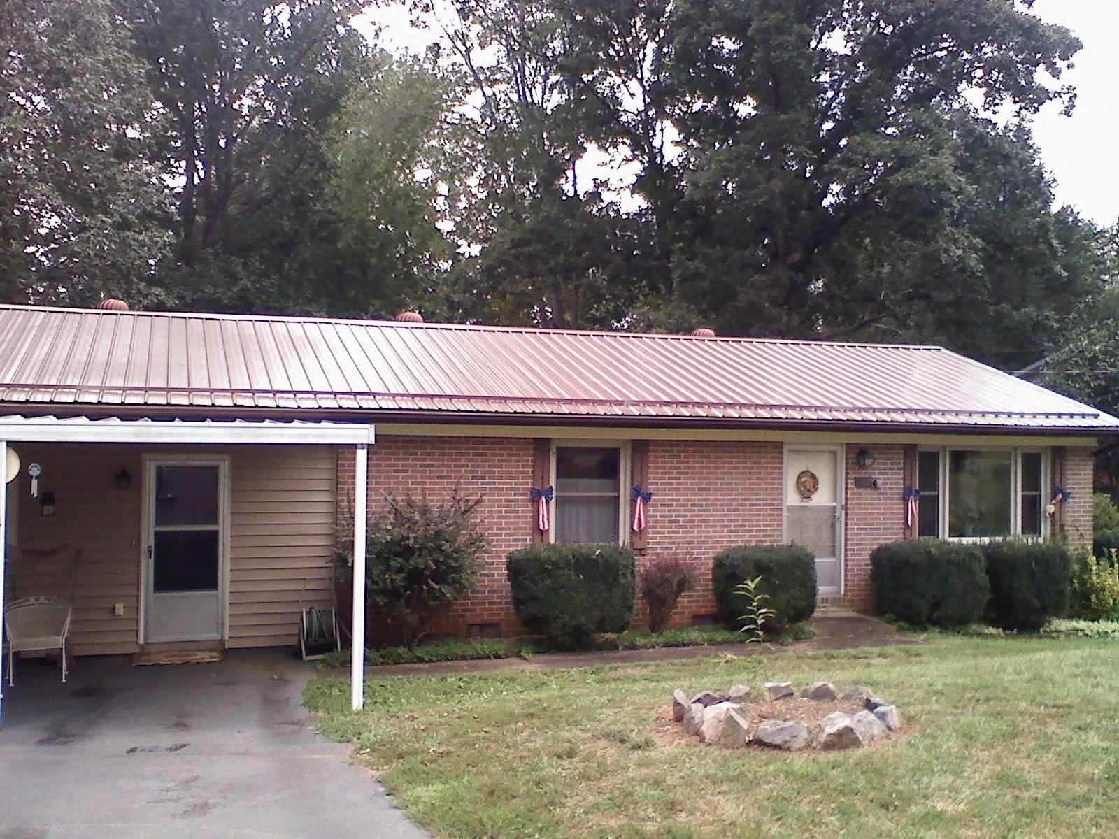 Bronze metal roof and carport on a brick ranch home — Roof Repair work by our crew in Mc Dermitt